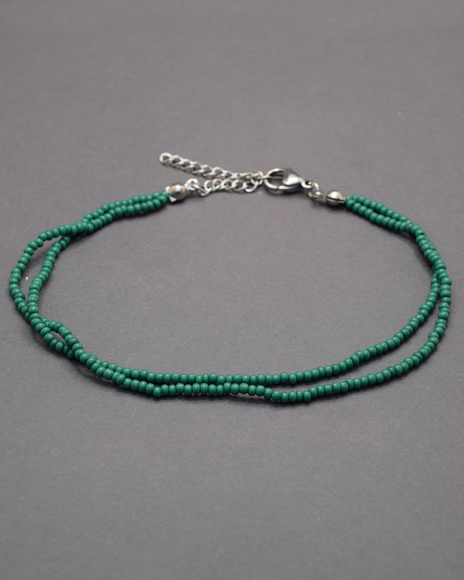 Pulseira dupla de tornozelo com missangas verdes, leve e vibrante, perfeita para um toque fresco e natural no teu estilo.