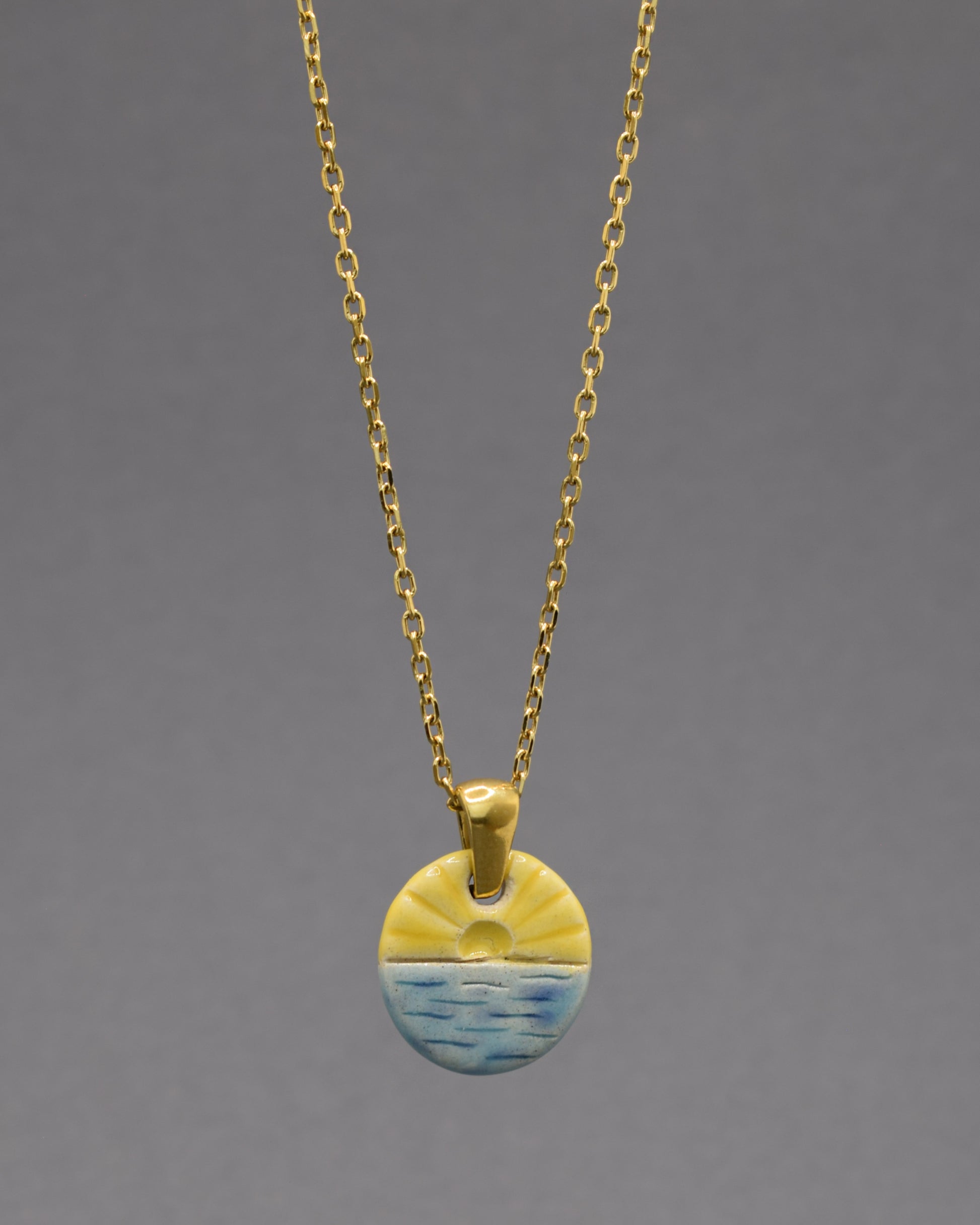 Colar com pendente de sol nascente, símbolo de novos começos e energia positiva para iluminar seu dia.