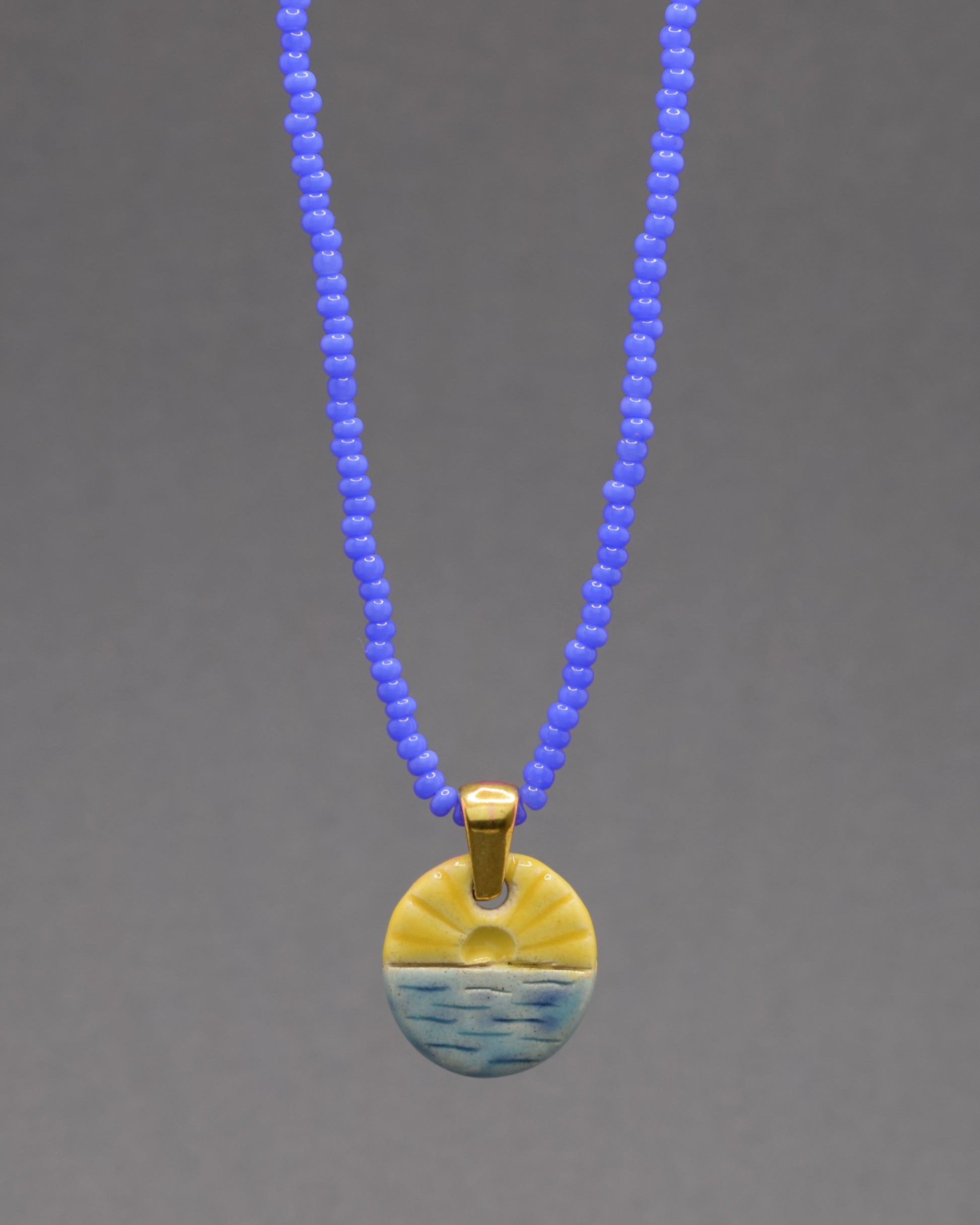 Colar com pendente de sol nascente, símbolo de novos começos e energia positiva para iluminar seu dia.