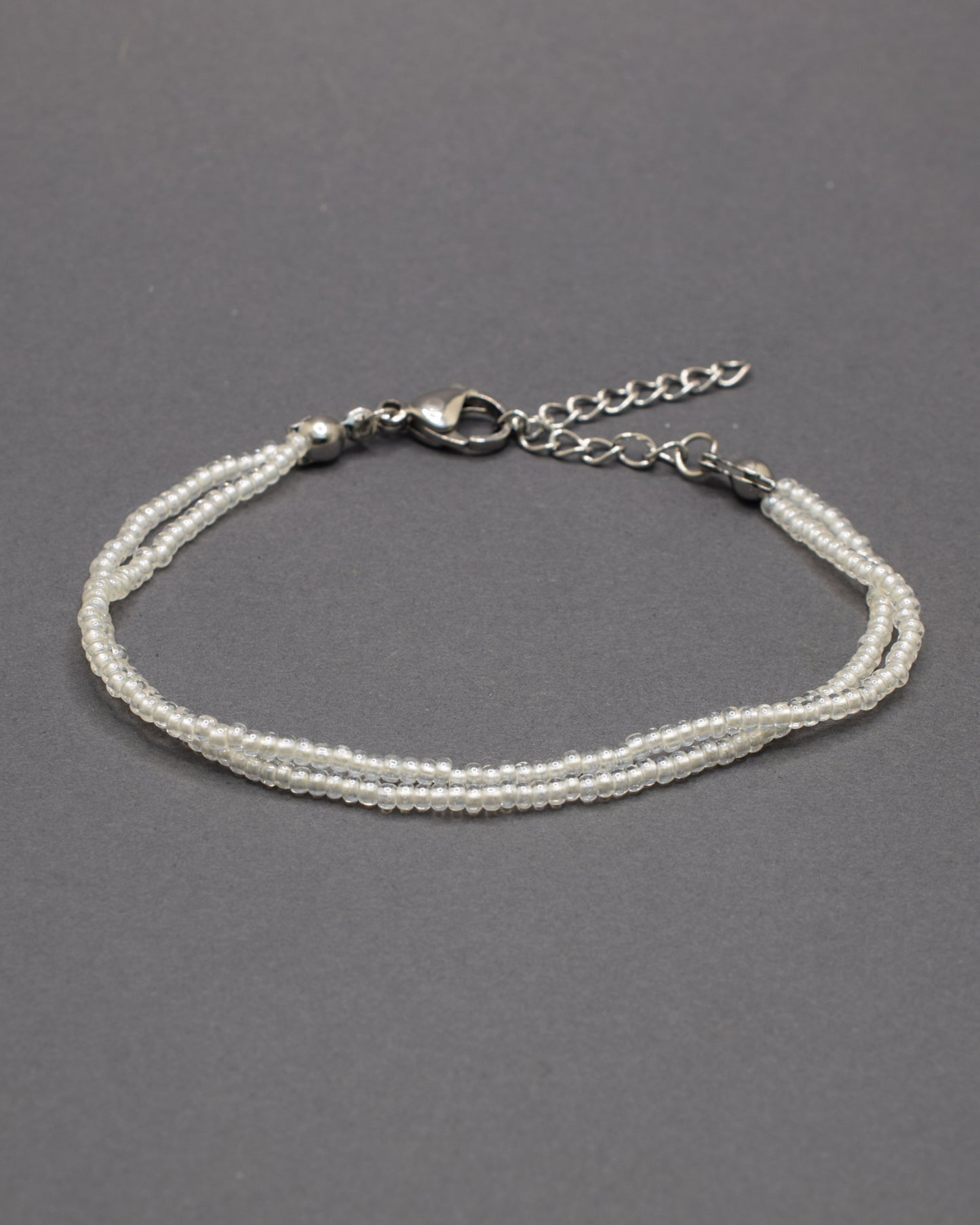 Pulseira Dupla de Missangas Brancas Semitransparentes, com design delicado e elegante. Ideal para adicionar suavidade ao seu look.