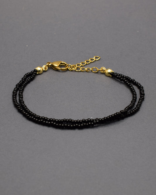 Pulseira dupla de missangas pretas, elegante e versátil, ideal para um look sofisticado e intemporal.