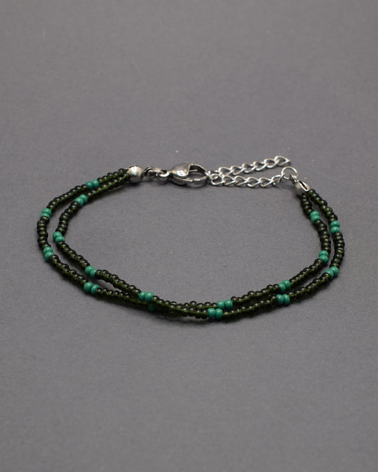 Pulseira dupla de missangas verde escuro semitransparentes em padrão elegante. Um acessório delicado e perfeito para complementar looks.