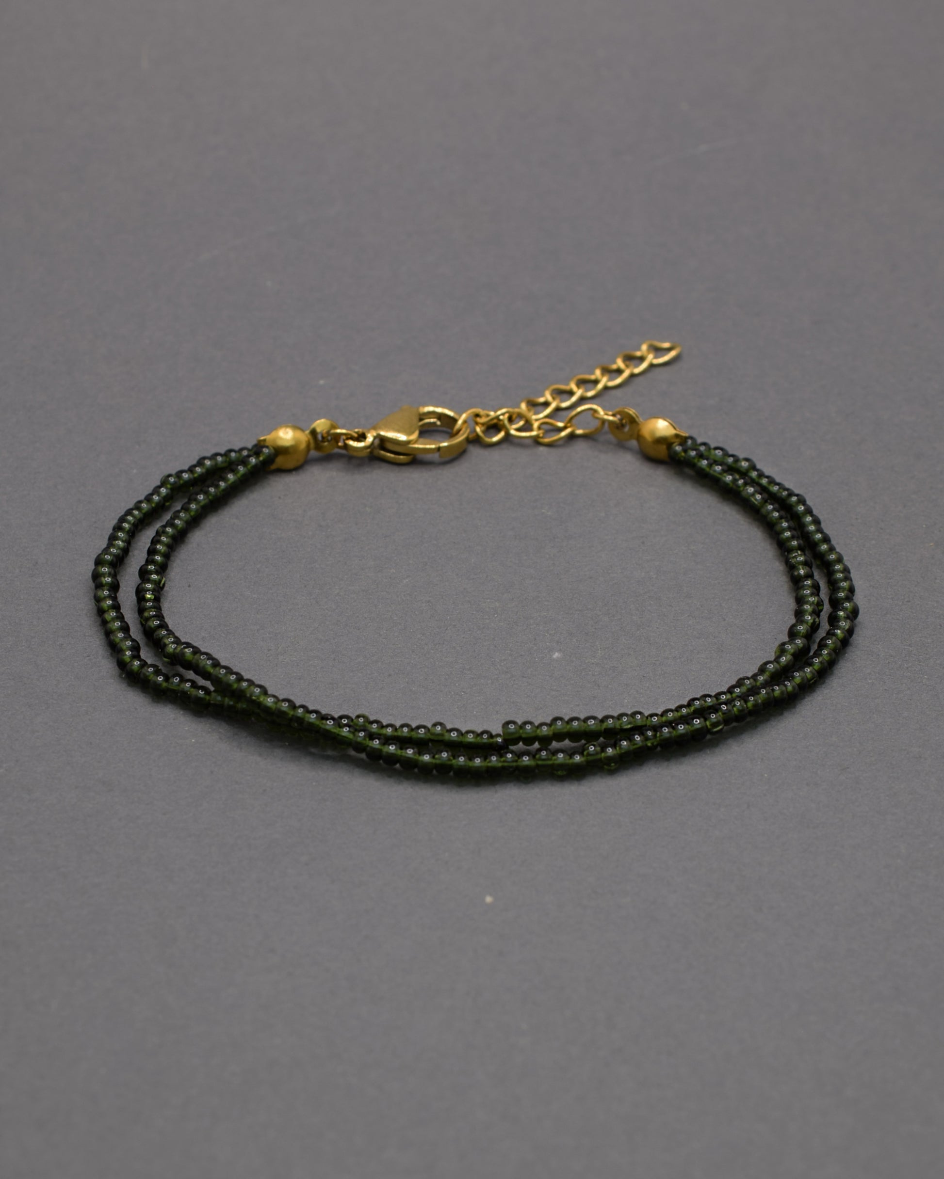 Pulseira dupla de missangas verde escuras semitransparentes. Design artesanal e elegante, ideal para um look sofisticado.