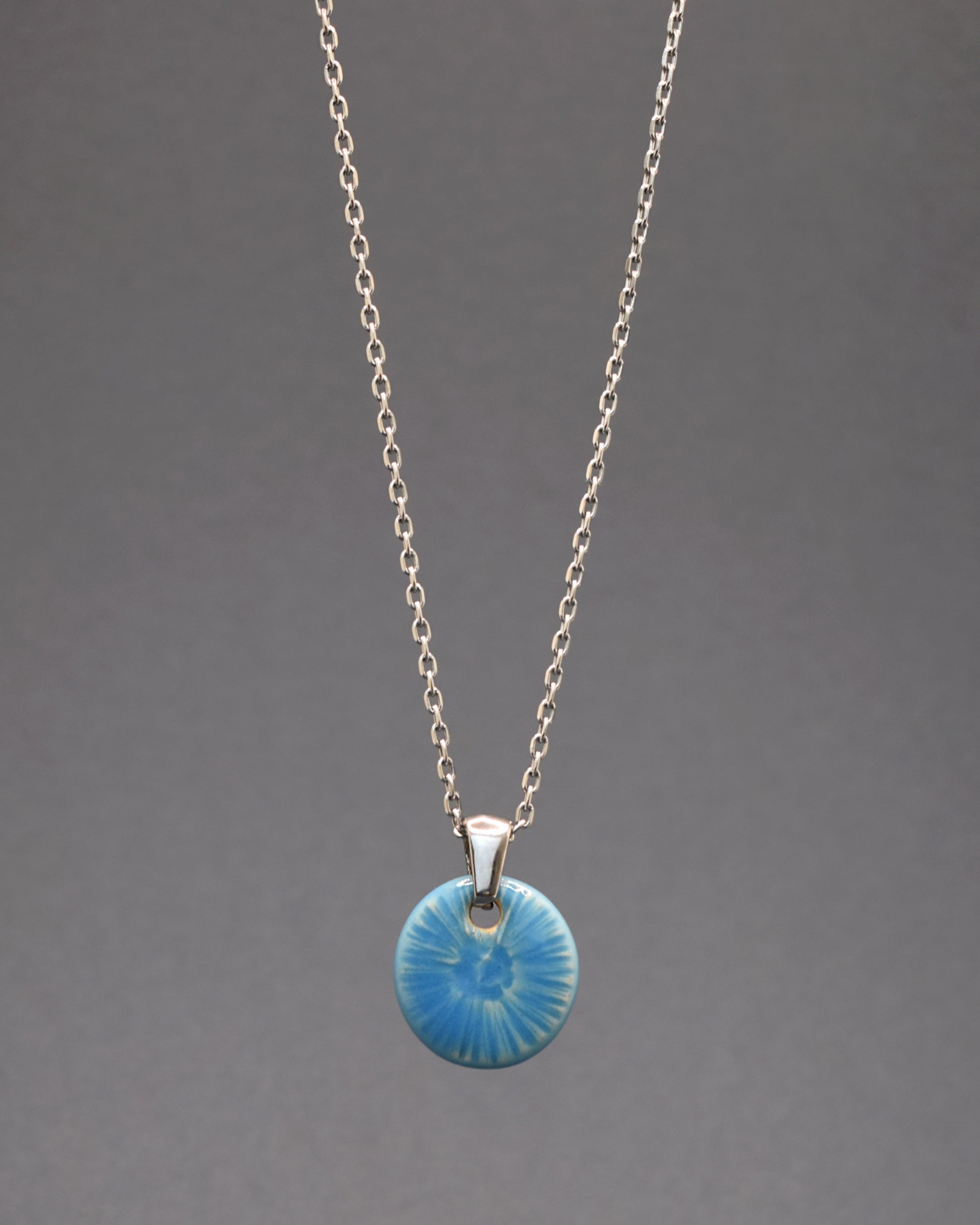 Colar envolvente em aço inoxidável, com um delicado pendente azul celeste inspirado na graciosidade de uma flor do mar. Uma peça única que adiciona um toque distintivo e encantador ao seu estilo.