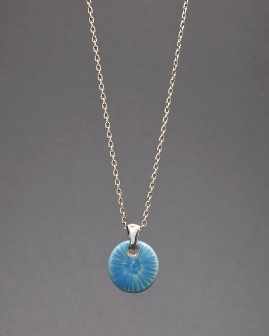 Colar envolvente em aço inoxidável, com um delicado pendente azul celeste inspirado na graciosidade de uma flor do mar. Uma peça única que adiciona um toque distintivo e encantador ao seu estilo.
