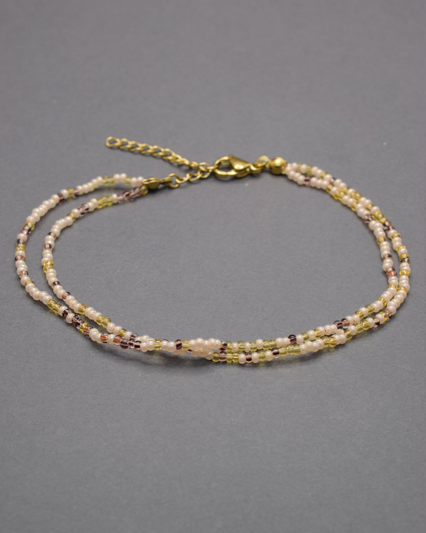 Pulseira dupla de tornozelo com missangas mix dourado, elegante e luminosa, perfeita para um toque sofisticado e cheio de charme.