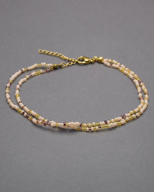 Pulseira dupla de tornozelo com missangas mix dourado, elegante e luminosa, perfeita para um toque sofisticado e cheio de charme.