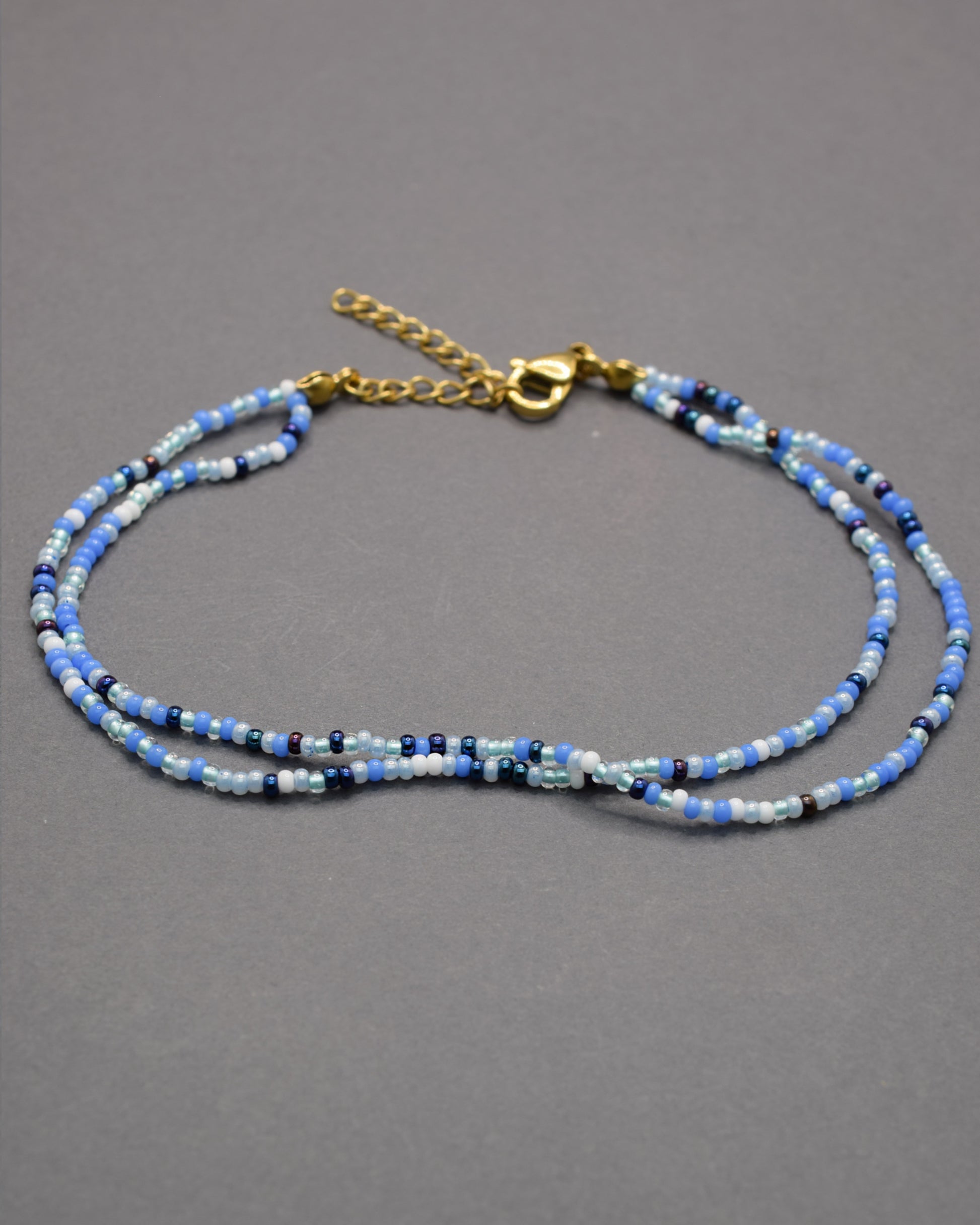 Pulseira dupla de tornozelo com missangas mix azul. Leve, vibrante e perfeita para dar um toque fresco ao teu verão.
