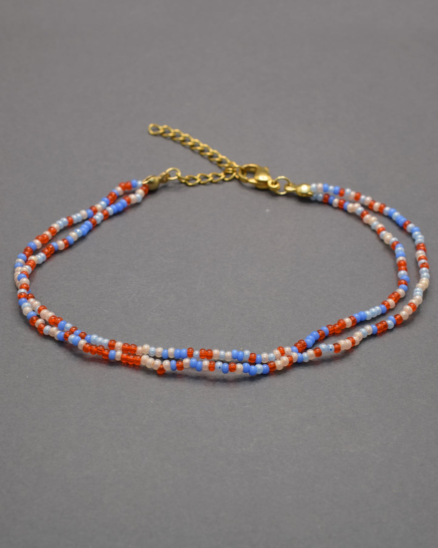 Pulseira dupla de tornozelo em missangas com mix de cores vibrantes. Alegre e moderna, perfeita para destacar o teu estilo com harmonia.
