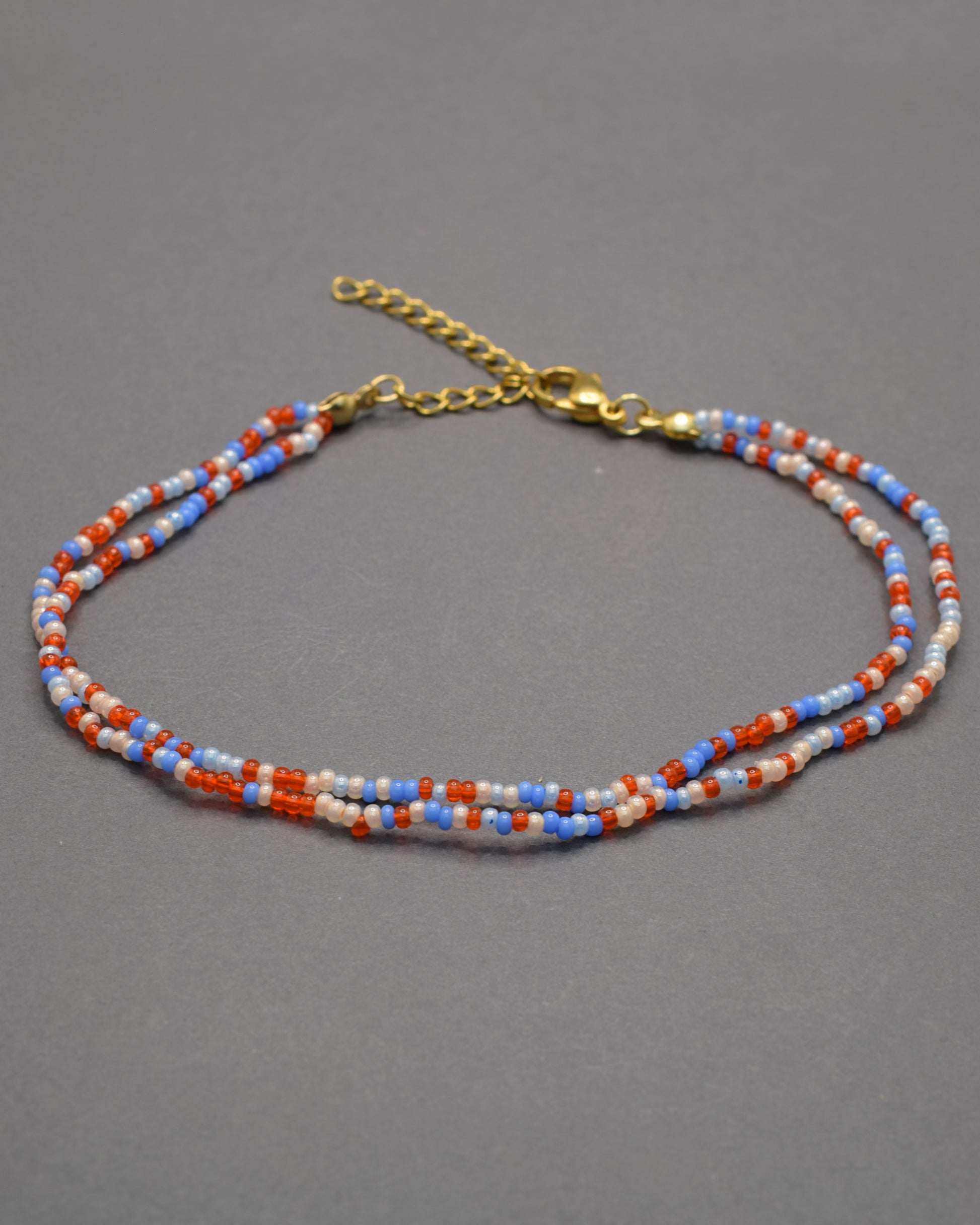 Pulseira dupla de tornozelo em missangas com mix de cores vibrantes. Alegre e moderna, perfeita para destacar o teu estilo com harmonia.