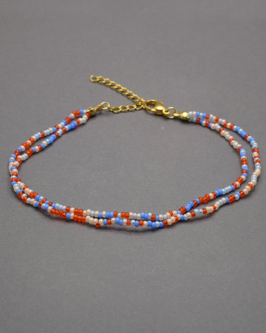 Pulseira dupla de tornozelo em missangas com mix de cores vibrantes. Alegre e moderna, perfeita para destacar o teu estilo com harmonia.