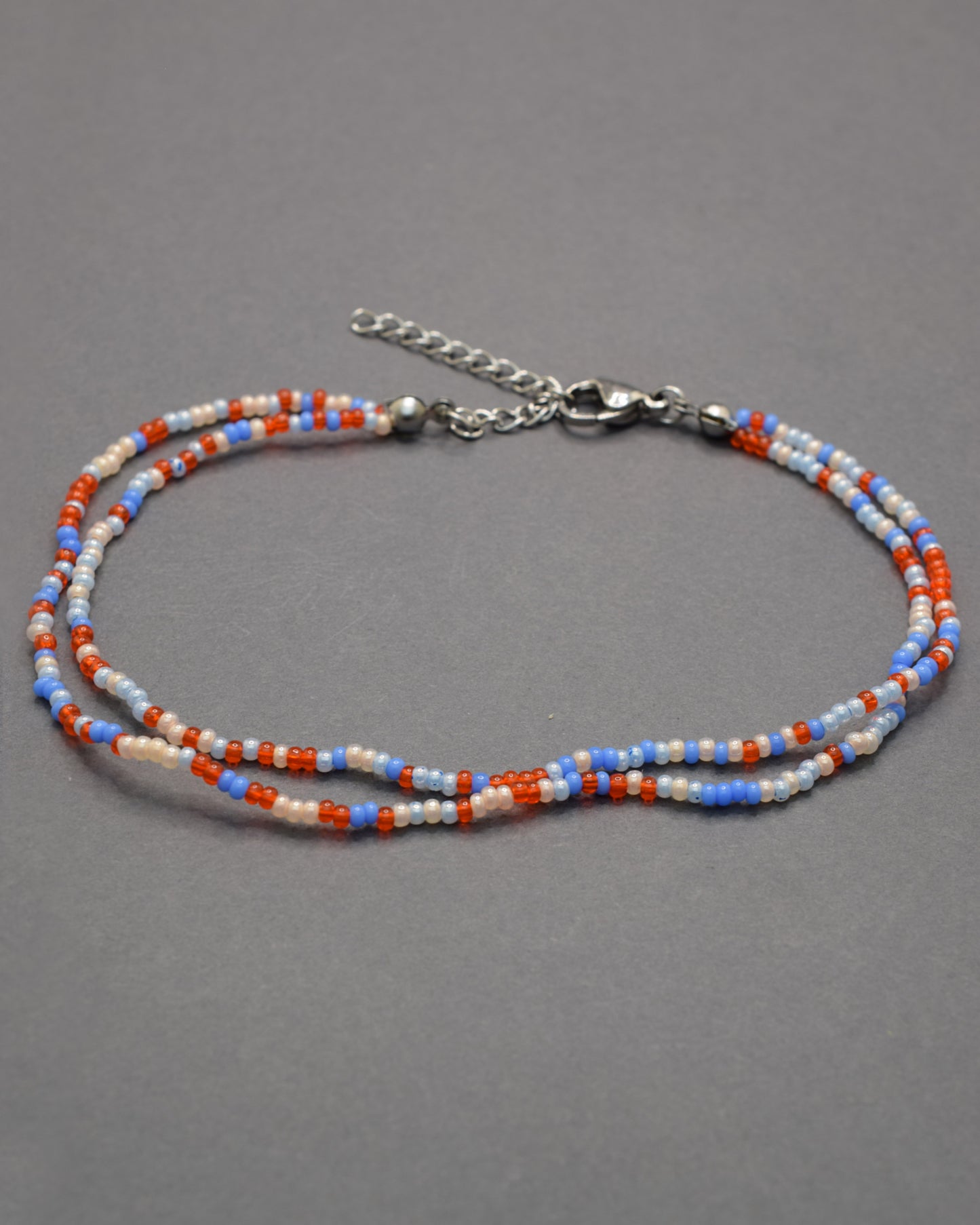 Pulseira dupla de tornozelo em missangas com mix de cores vibrantes. Alegre e moderna, perfeita para destacar o teu estilo com harmonia.