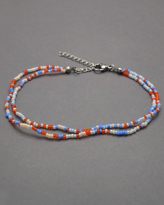 Pulseira dupla de tornozelo em missangas com mix de cores vibrantes. Alegre e moderna, perfeita para destacar o teu estilo com harmonia.