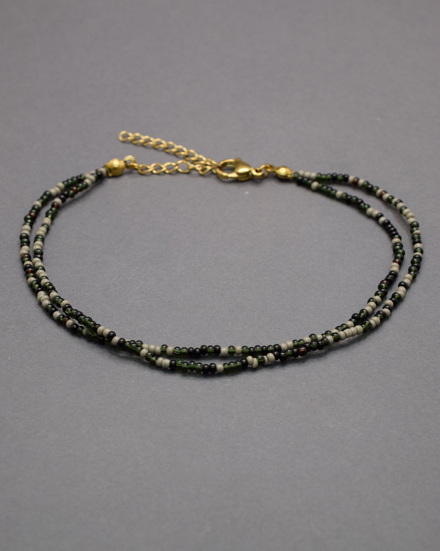 Pulseira dupla de tornozelo com missangas pretas em mix sofisticado, moderna e versátil, perfeita para um look elegante e marcante.