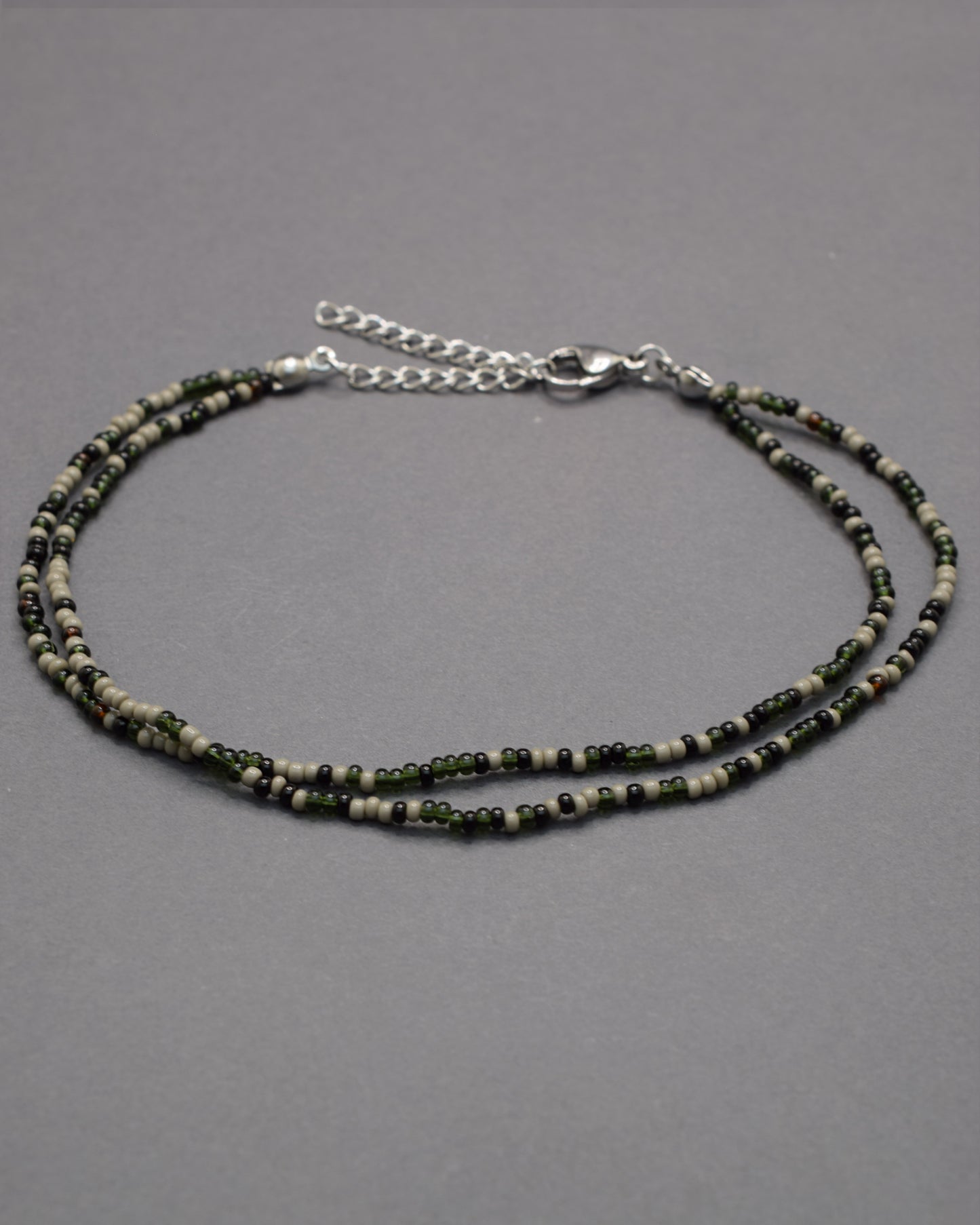 Pulseira dupla de tornozelo com missangas pretas em mix sofisticado, moderna e versátil, perfeita para um look elegante e marcante.