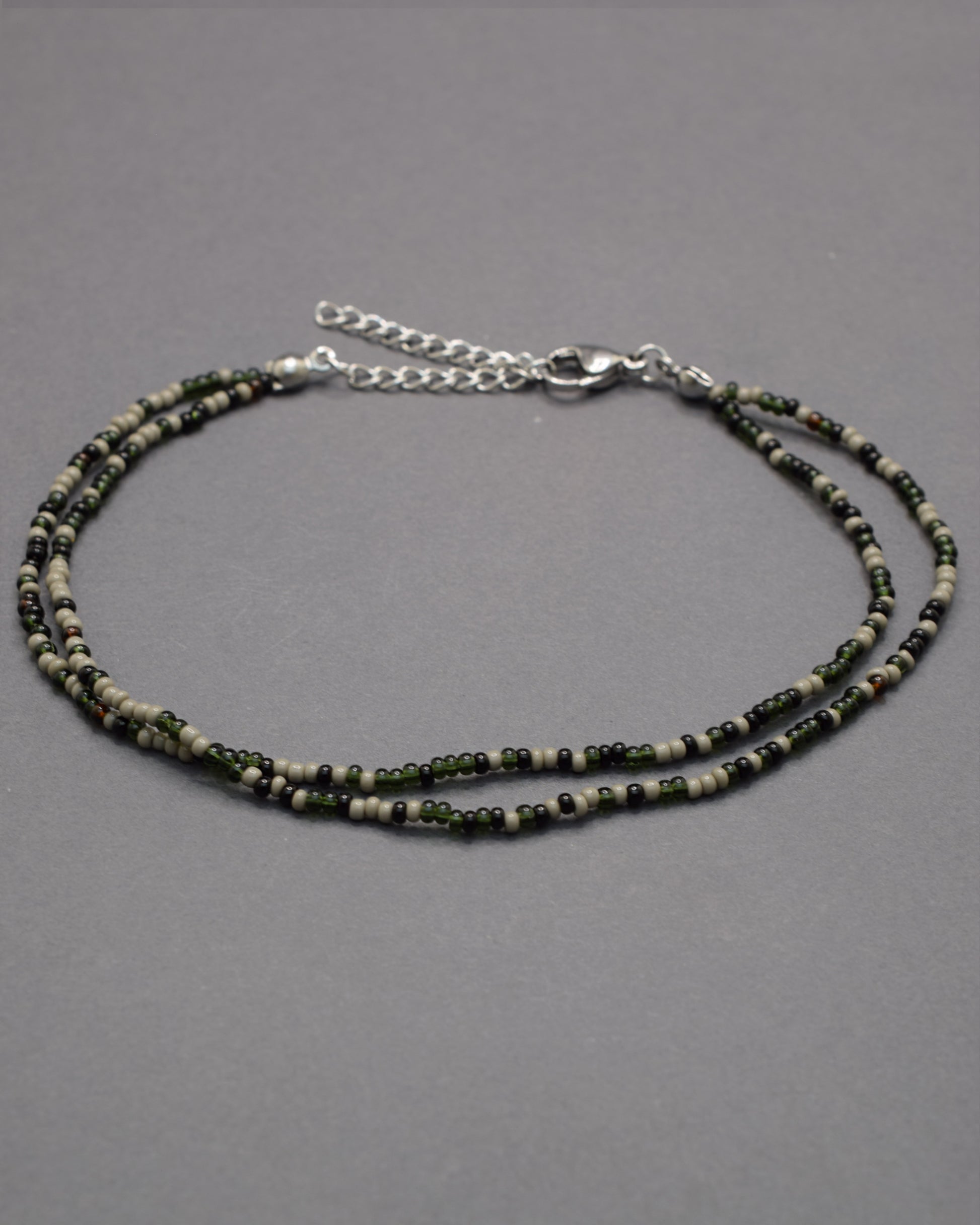Pulseira dupla de tornozelo com missangas pretas em mix sofisticado, moderna e versátil, perfeita para um look elegante e marcante.