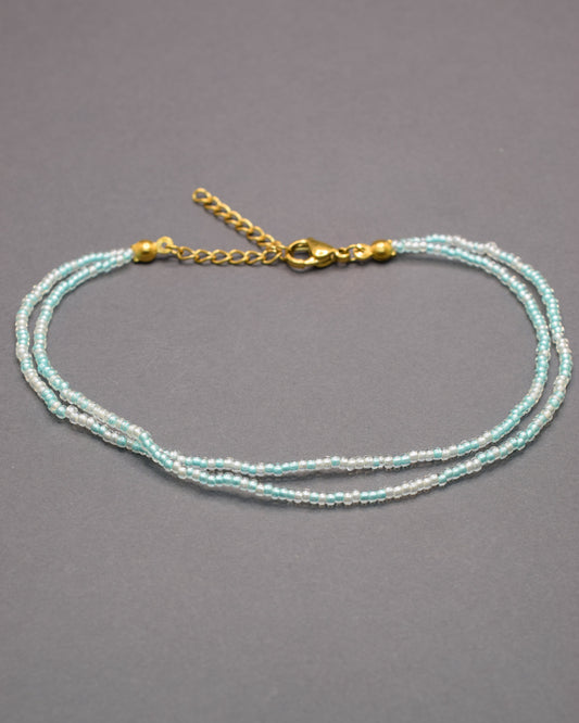 Pulseira dupla de tornozelo com missangas turquesa semitransparentes, leve e vibrante, ideal para um look fresco e cheio de estilo.