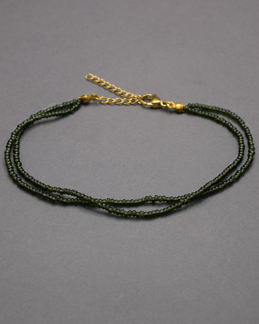 Pulseira dupla de tornozelo com missangas verde-escuras semitransparentes, elegante e envolvente, ideal para um toque natural e sofisticado.