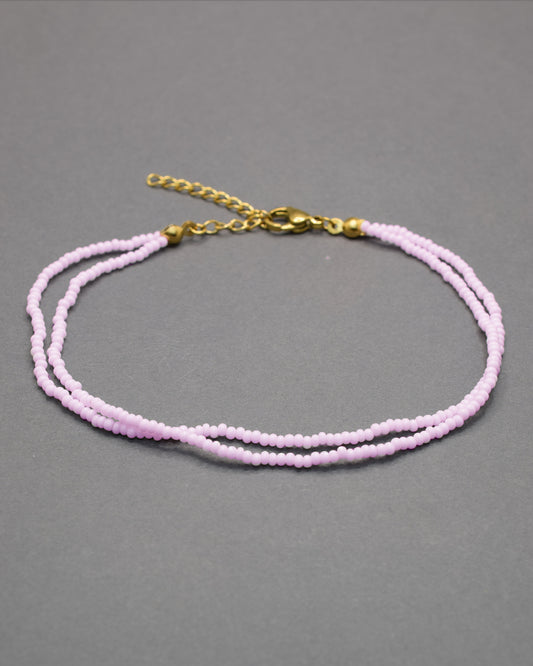 Pulseira dupla de tornozelo em missangas rosa claro, delicada e feminina, ideal para um look leve, elegante e cheio de charme.