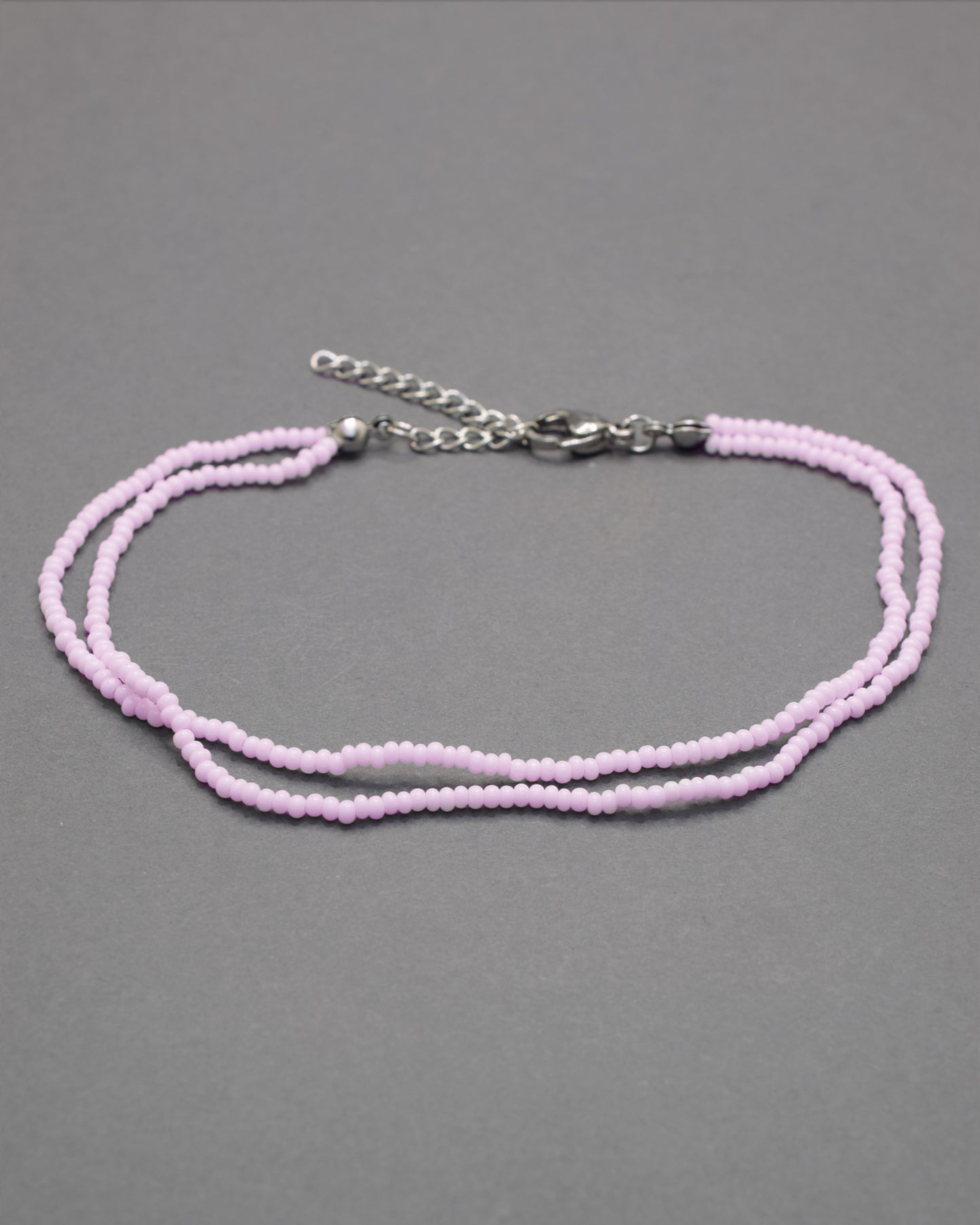 Pulseira dupla de tornozelo em missangas rosa claro, delicada e feminina, ideal para um look leve, elegante e cheio de charme.
