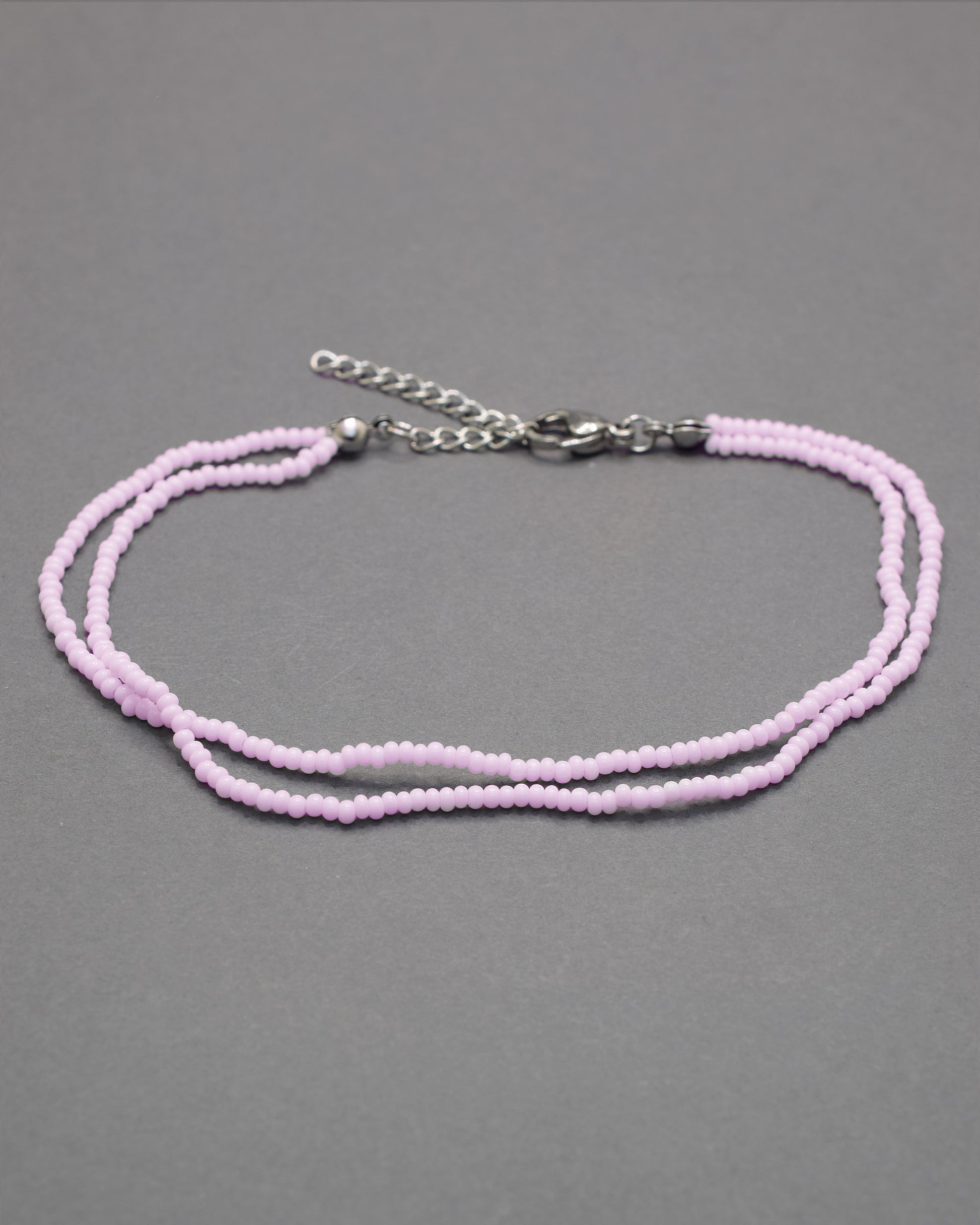 Pulseira dupla de tornozelo em missangas rosa claro, delicada e feminina, ideal para um look leve, elegante e cheio de charme.