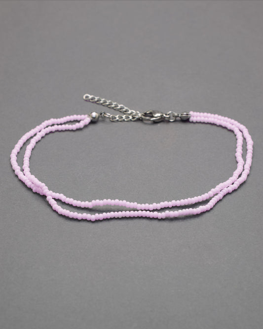 Pulseira dupla de tornozelo em missangas rosa claro, delicada e feminina, ideal para um look leve, elegante e cheio de charme.