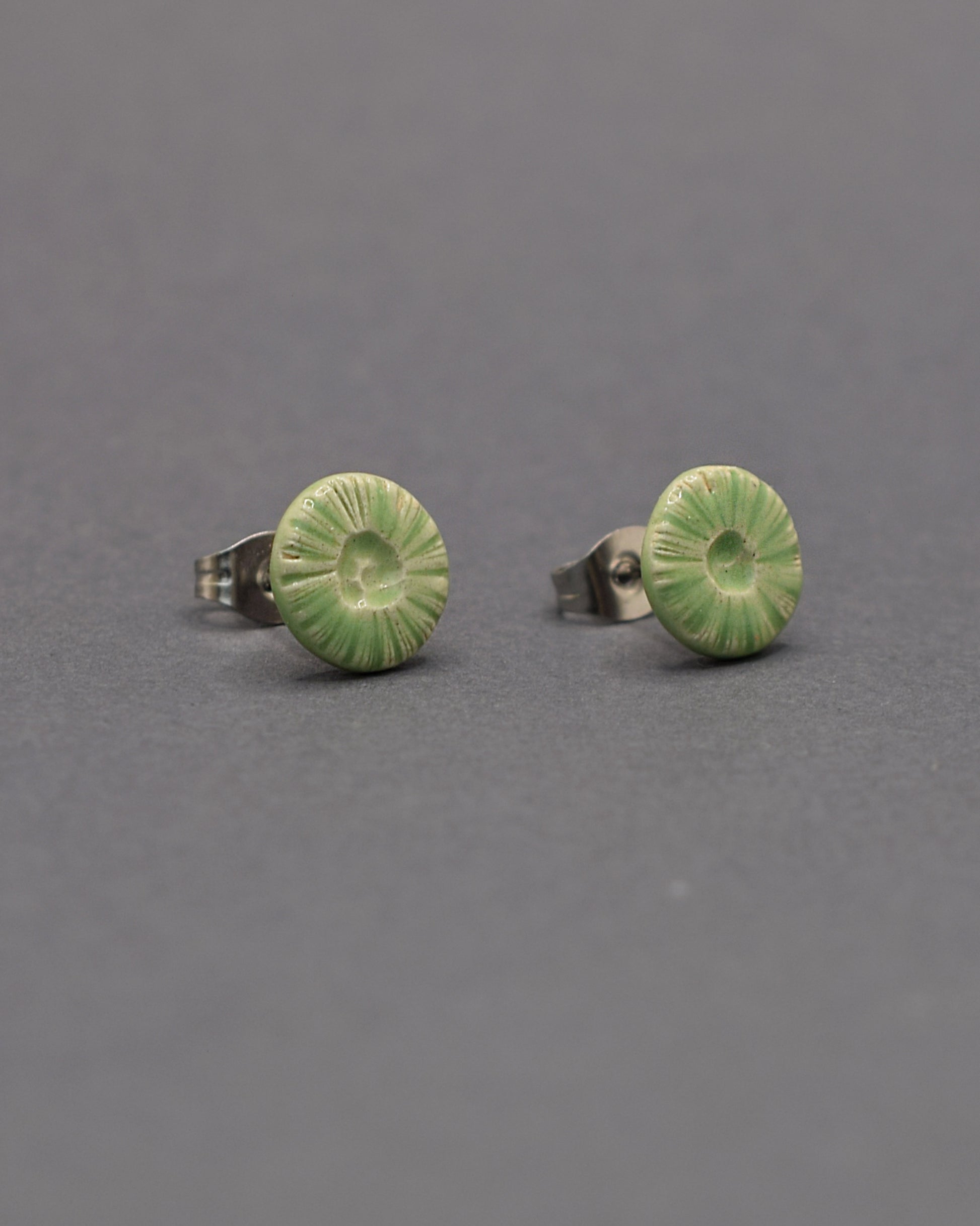 Brincos stud em cerâmica, com design flor do mar em verde claro. Perfeitos para um toque único e moderno no seu look.