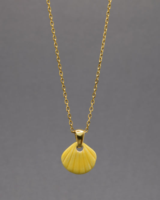 Colar com pendente de concha pintada em amarelo. Peça artesanal em cerâmica que celebra o verão com cor e elegância.