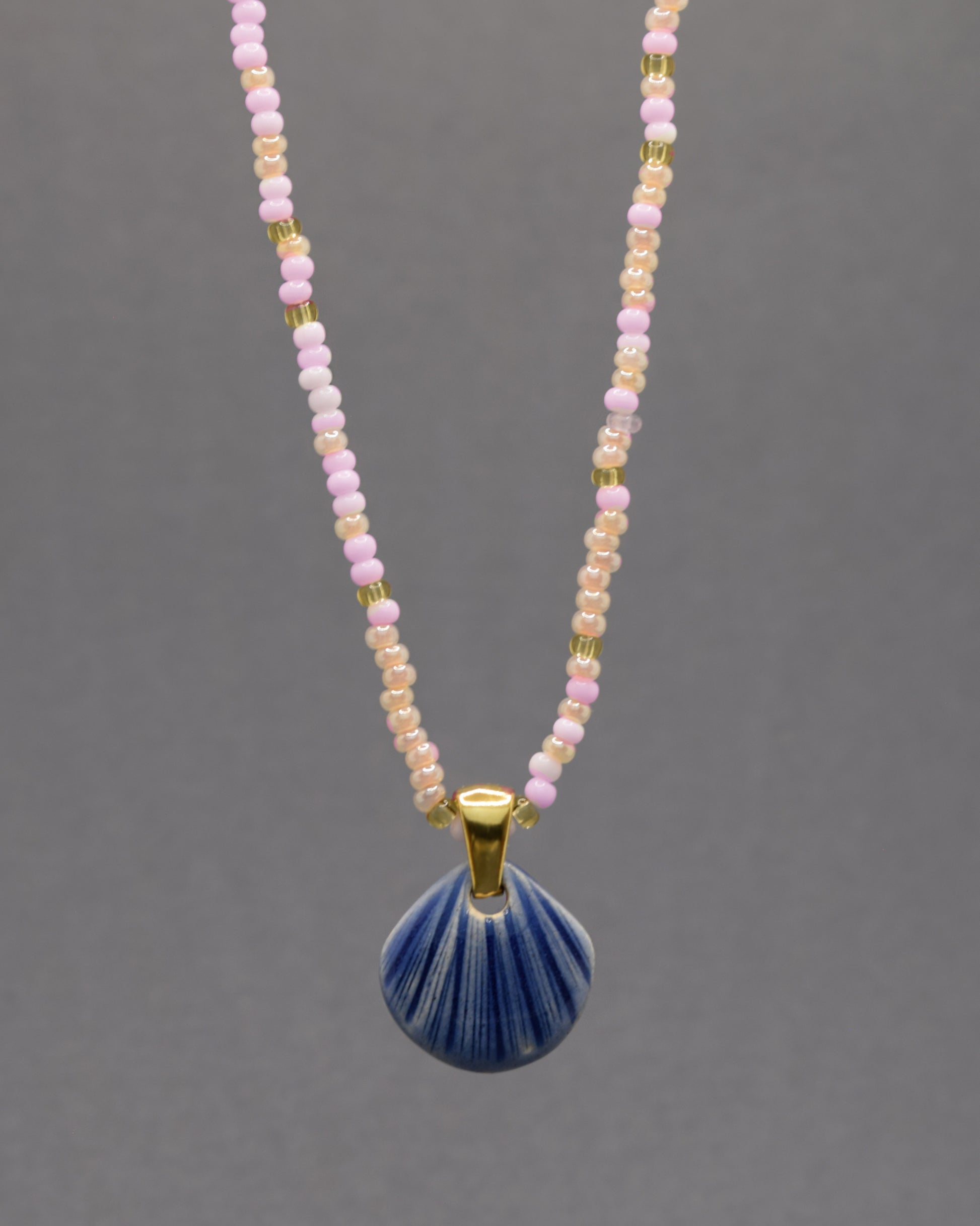 Colar artesanal com pendente de concha em cerâmica azul escuro, inspirado no mar e na serenidade. Elegante e versátil para qualquer ocasião.