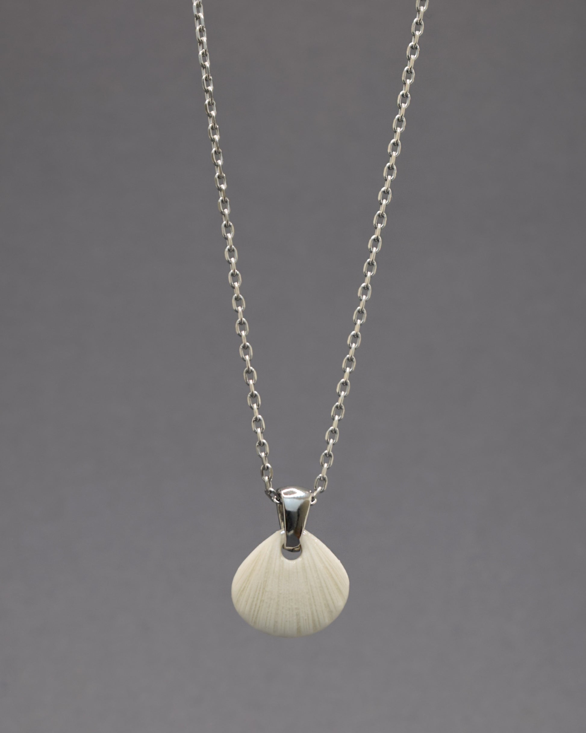 Colar com pendente de porcelana em forma de concha. Peça delicada, feita à mão, ideal para amantes do mar e do design artesanal.