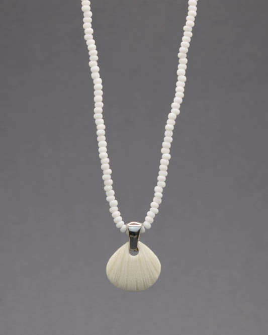Colar com pendente de porcelana em forma de concha. Peça delicada, feita à mão, ideal para amantes do mar e do design artesanal.