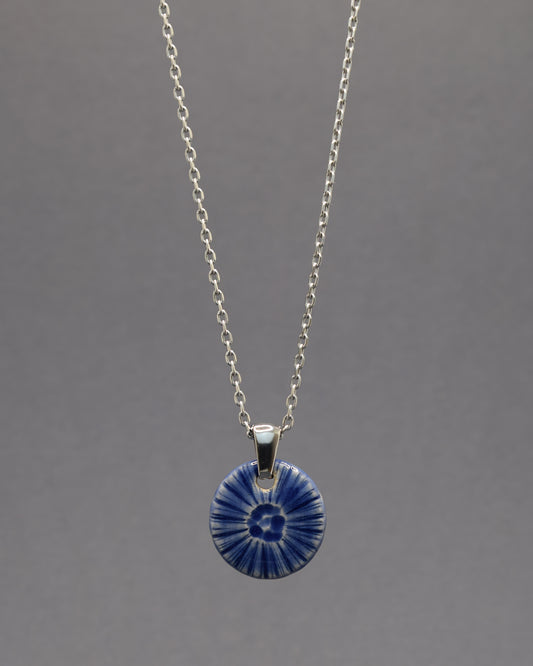 Colar artesanal em cerâmica azul escuro, inspirado na força do mar. Elegância contemporânea com acabamento único e orgânico.