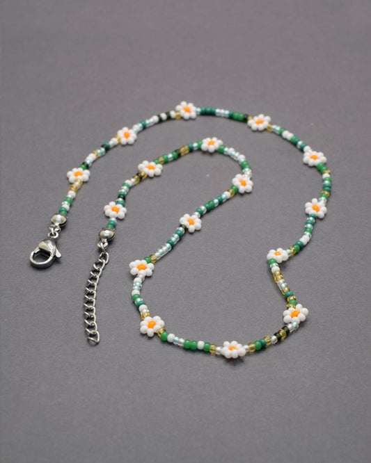 Colar com flores brancas e missangas mix em tons verdes, delicado e harmonioso, perfeito para um look fresco e natural.