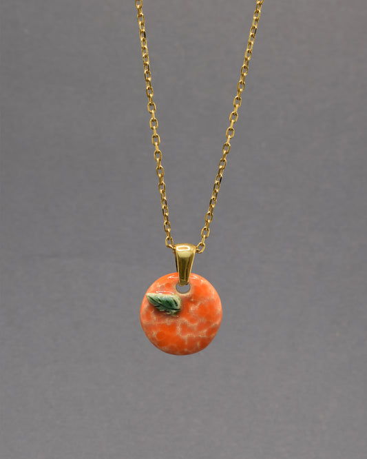 Colar com laranja e folha em cerâmica pintada à mão. Um apontamento de cor inspirado nos pomares portugueses, perfeito para dar vida a qualquer look.
