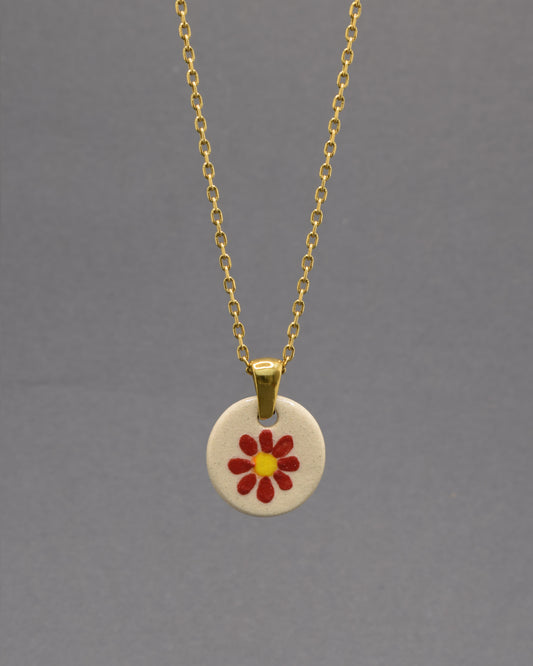 Colar Margarida Vermelha com pendente em cerâmica artesanal. Design vibrante e cheio de energia, perfeito para o seu estilo.