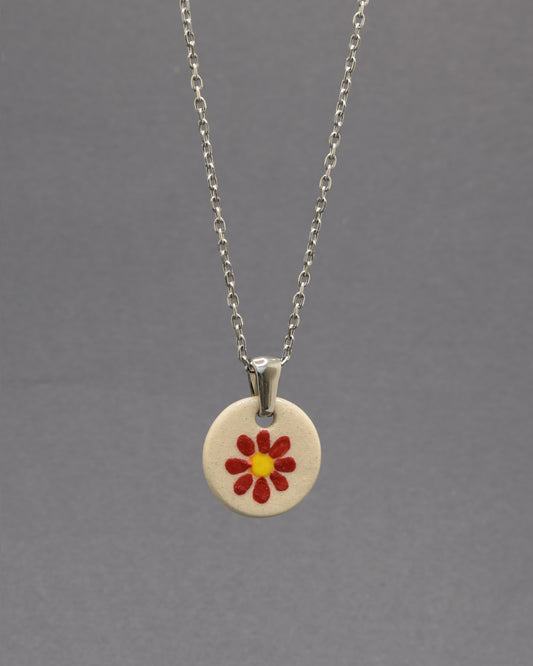 Colar Margarida Vermelha com pendente em cerâmica artesanal. Design vibrante e cheio de energia, perfeito para o seu estilo.