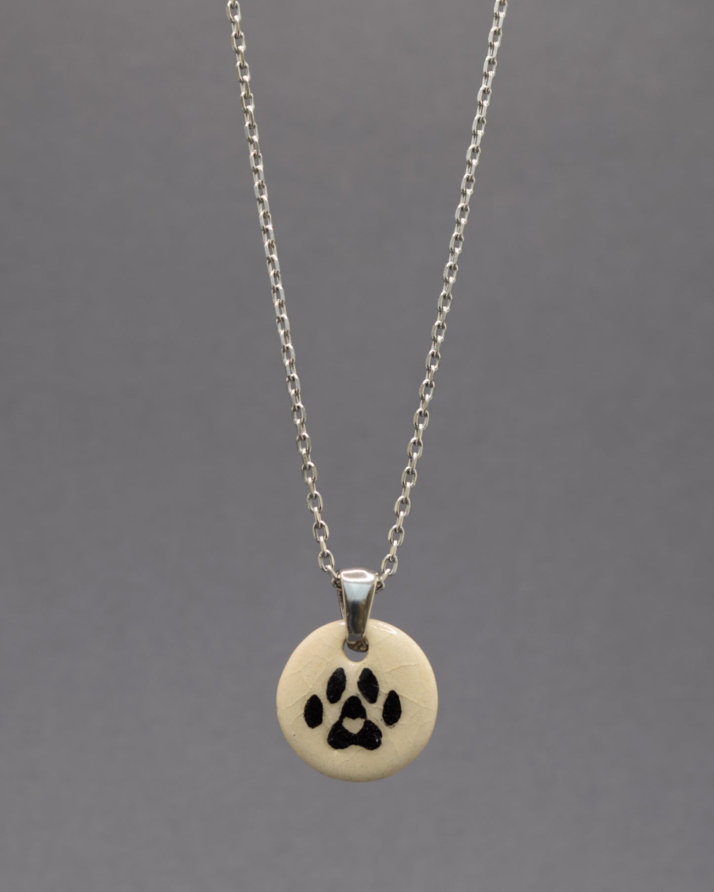 Colar com pendente de pata de cão em cerâmica, feito à mão, simboliza amor pelos animais com um toque delicado e cheio de significado.