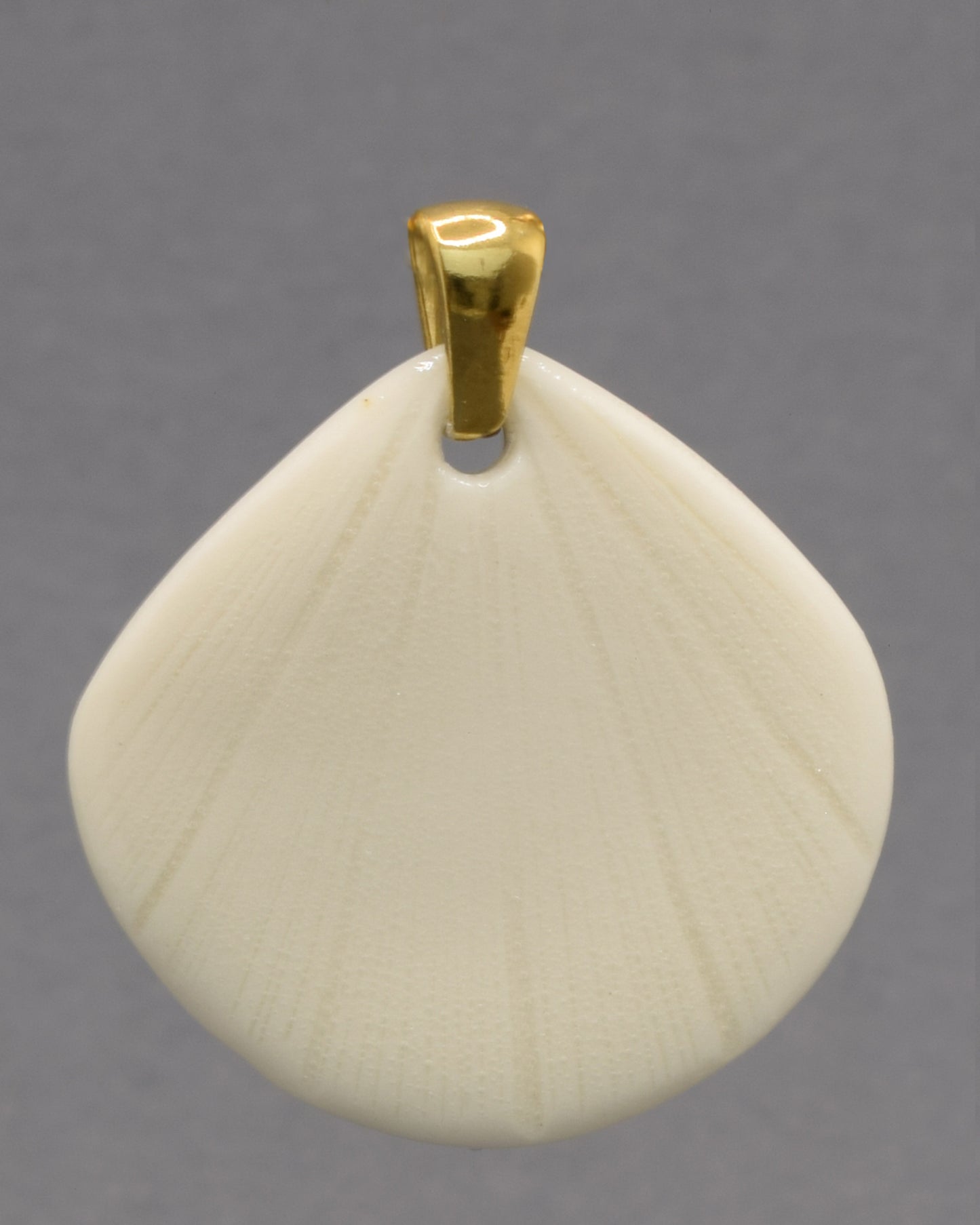 Pendente de porcelana em forma de concha, moldado e acabado à mão. Uma peça elegante que evoca a beleza do mar com delicadeza e intemporalidade.