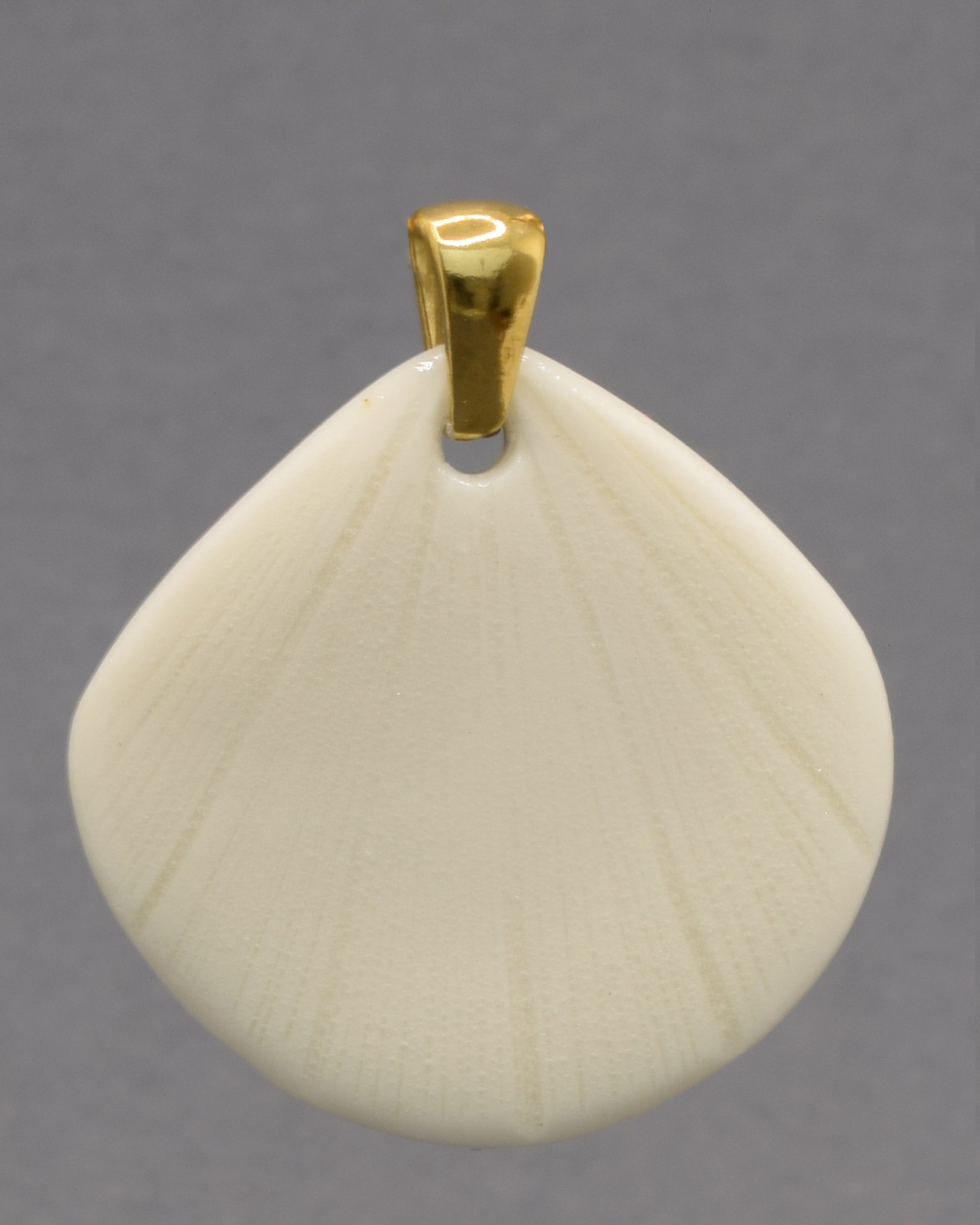 Pendente de porcelana em forma de concha, moldado e acabado à mão. Uma peça elegante que evoca a beleza do mar com delicadeza e intemporalidade.