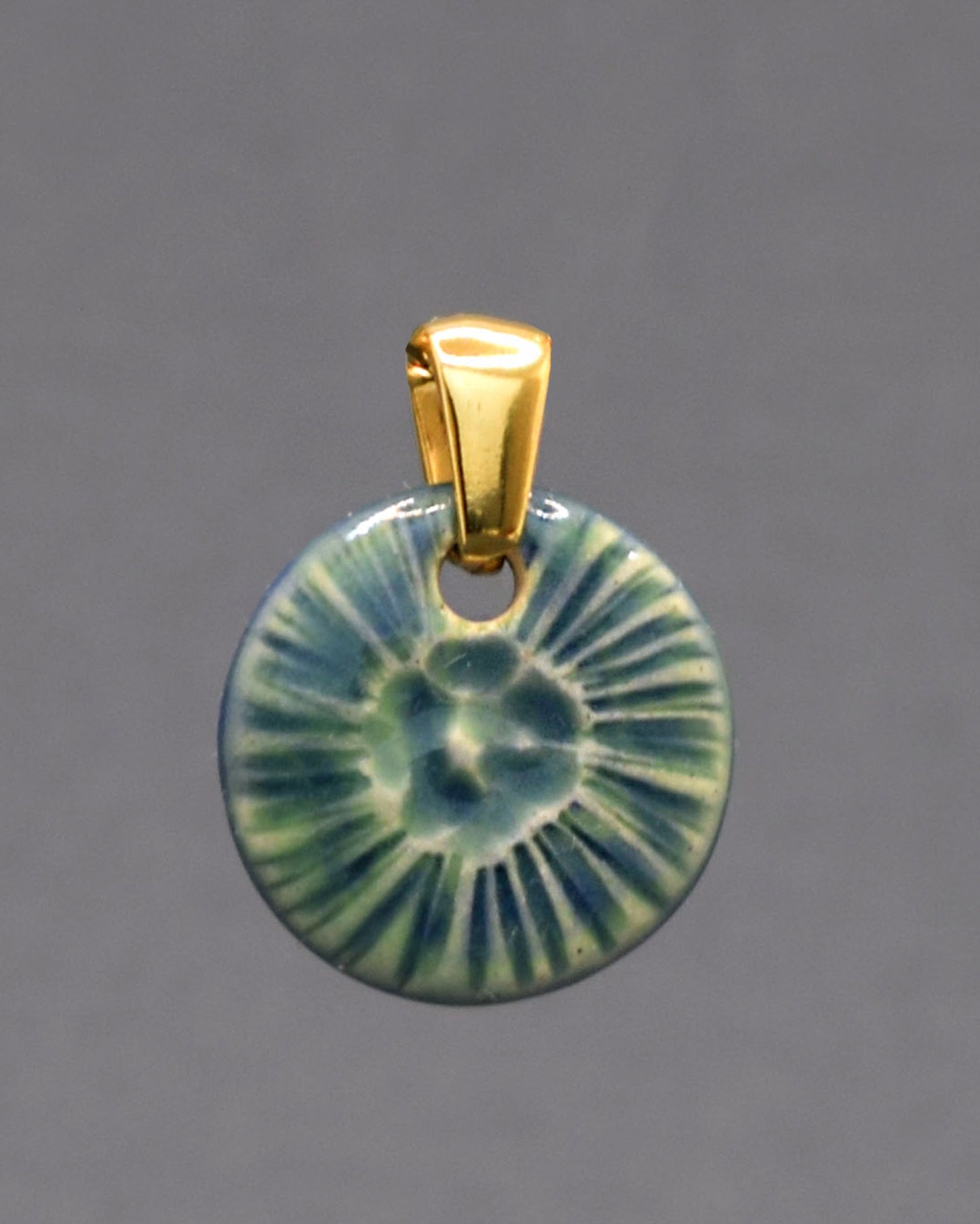 Pendente em cerâmica artesanal, inspirado numa flor do mar, em verde musgo, evocando a harmonia entre a natureza e o oceano.