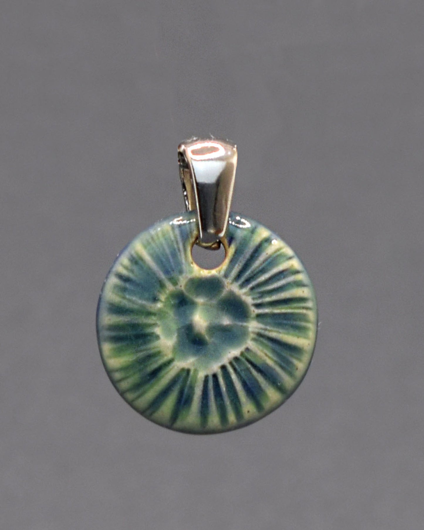 Pendente em cerâmica artesanal, inspirado numa flor do mar, em verde musgo, evocando a harmonia entre a natureza e o oceano.