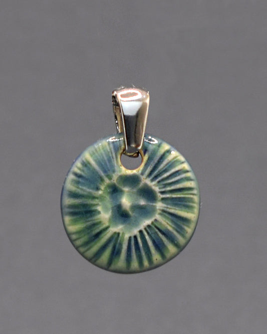 Pendente em cerâmica artesanal, inspirado numa flor do mar, em verde musgo, evocando a harmonia entre a natureza e o oceano.