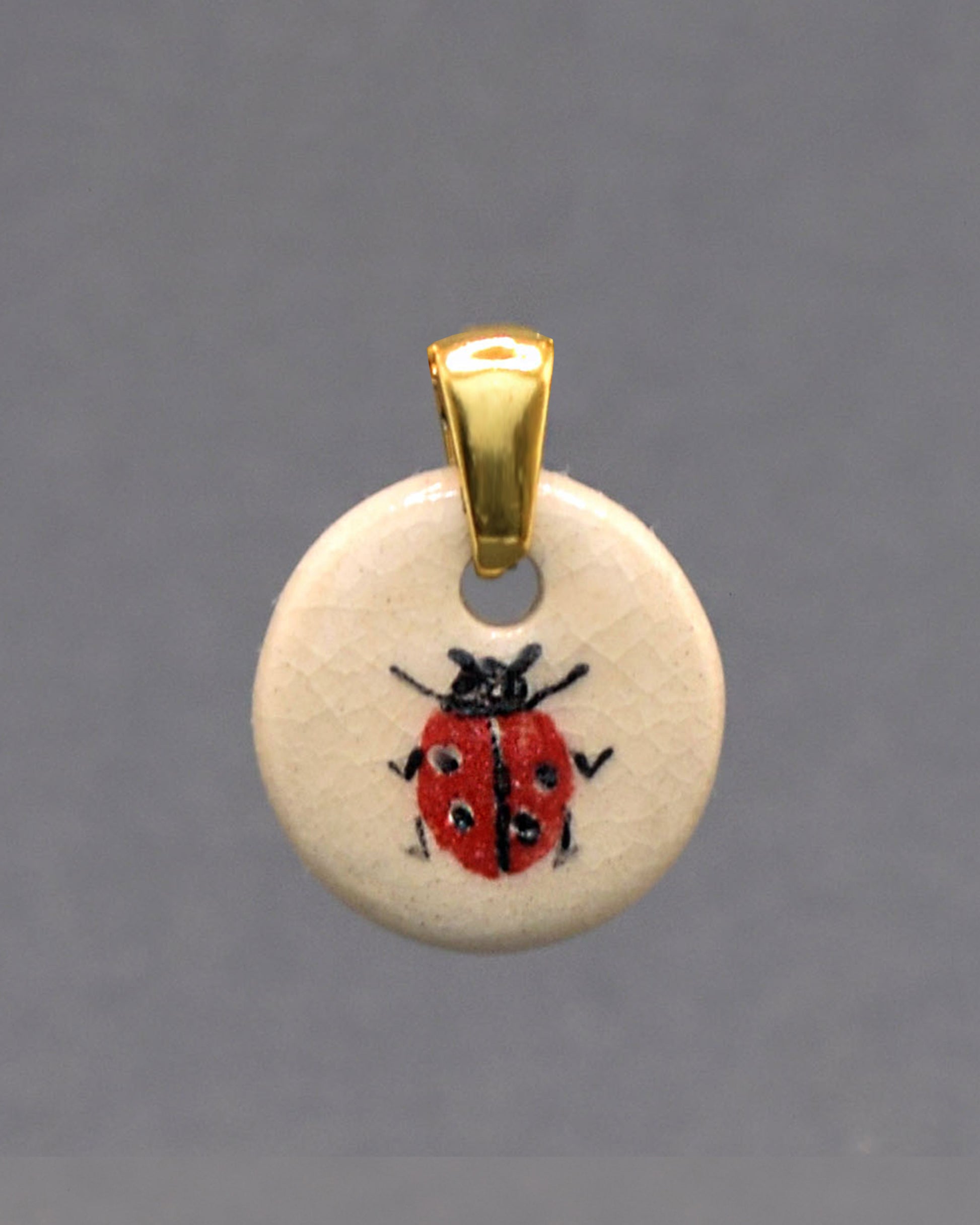 Pendente em cerâmica artesanal com joaninha pintada à mão, símbolo de sorte e alegria, ideal para quem aprecia detalhes únicos.