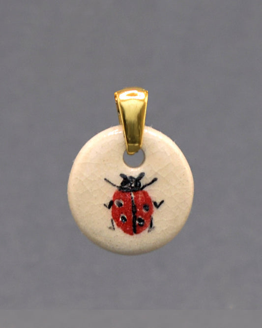 Pendente em cerâmica artesanal com joaninha pintada à mão, símbolo de sorte e alegria, ideal para quem aprecia detalhes únicos.