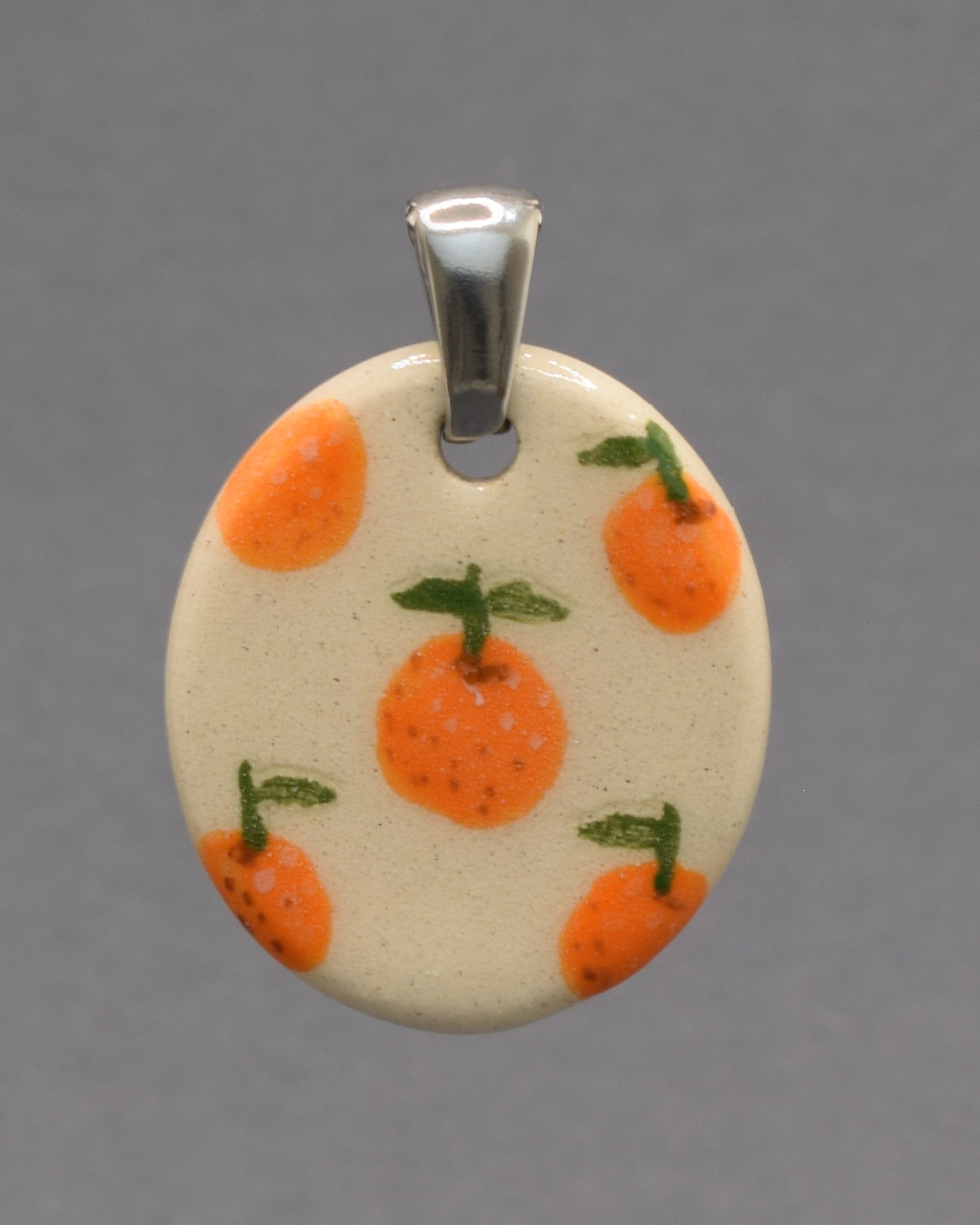 Pendente de cerâmica pintado à mão com laranjas vibrantes. Uma peça artesanal inspirada na frescura dos laranjais, cheia de cor e autenticidade.