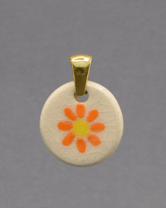 Pendente de cerâmica pintado à mão com uma delicada margarida laranja. As cores vibrantes e o acabamento artesanal tornam cada peça única e cheia de encanto.