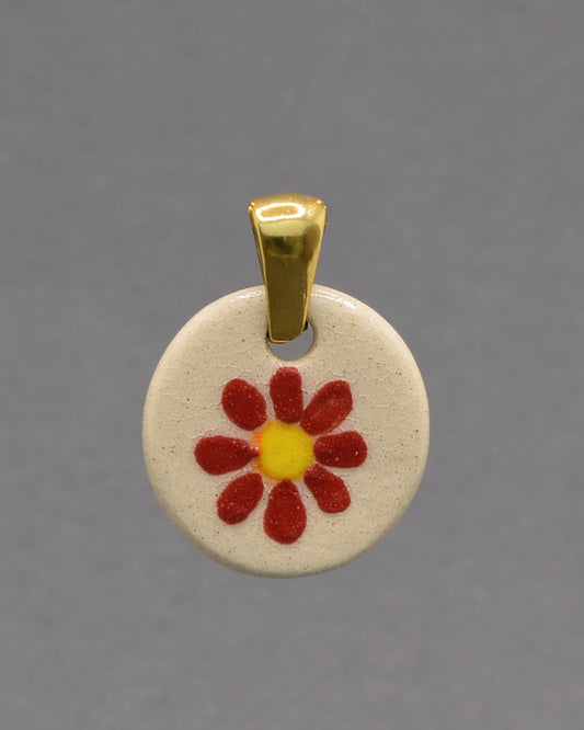 Pendente de cerâmica pintado à mão com uma delicada margarida vermelha. Uma peça artesanal que combina elegância, cor e um toque inspirado na natureza.