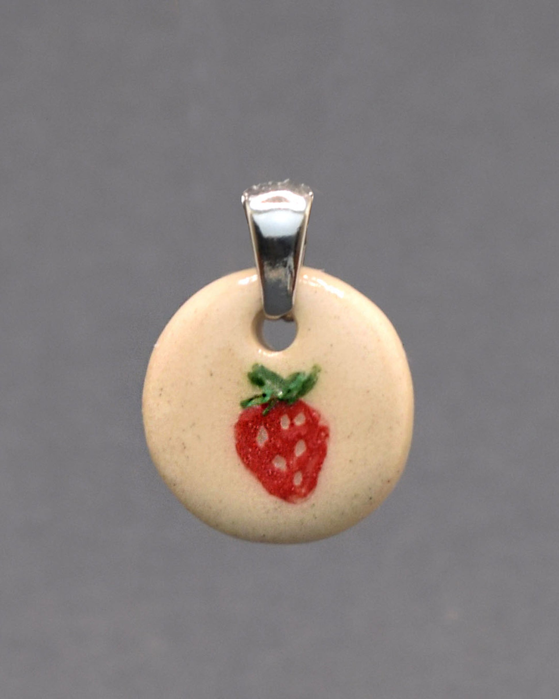Pendente em cerâmica com morango pintado à mão. Delicado, artesanal e cheio de charme para um toque doce no teu estilo.