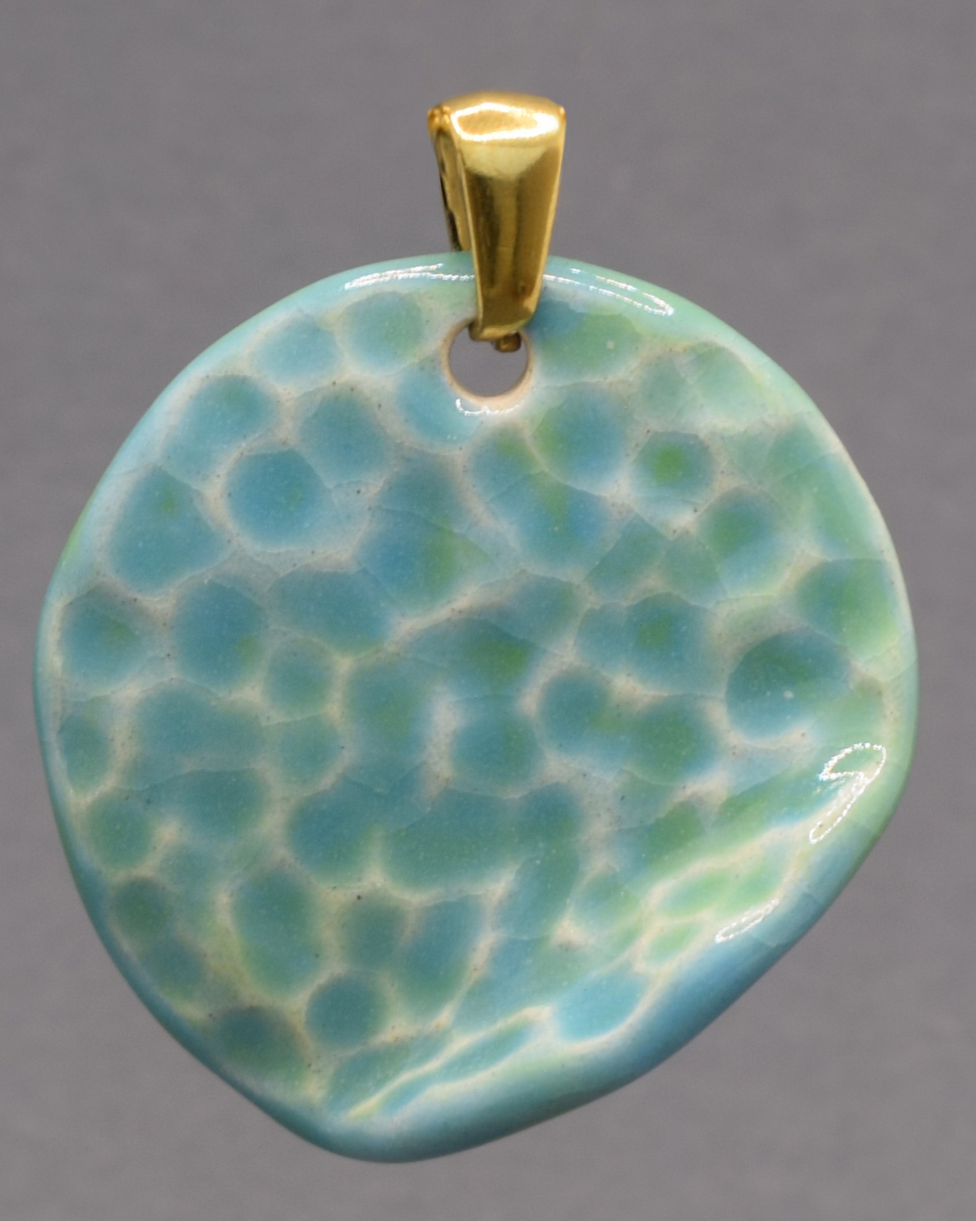 Pendente de cerâmica com textura inspirada nas ondas do mar e acabamento em tons turquesa. Uma peça artesanal única, elegante e cheia de personalidade.