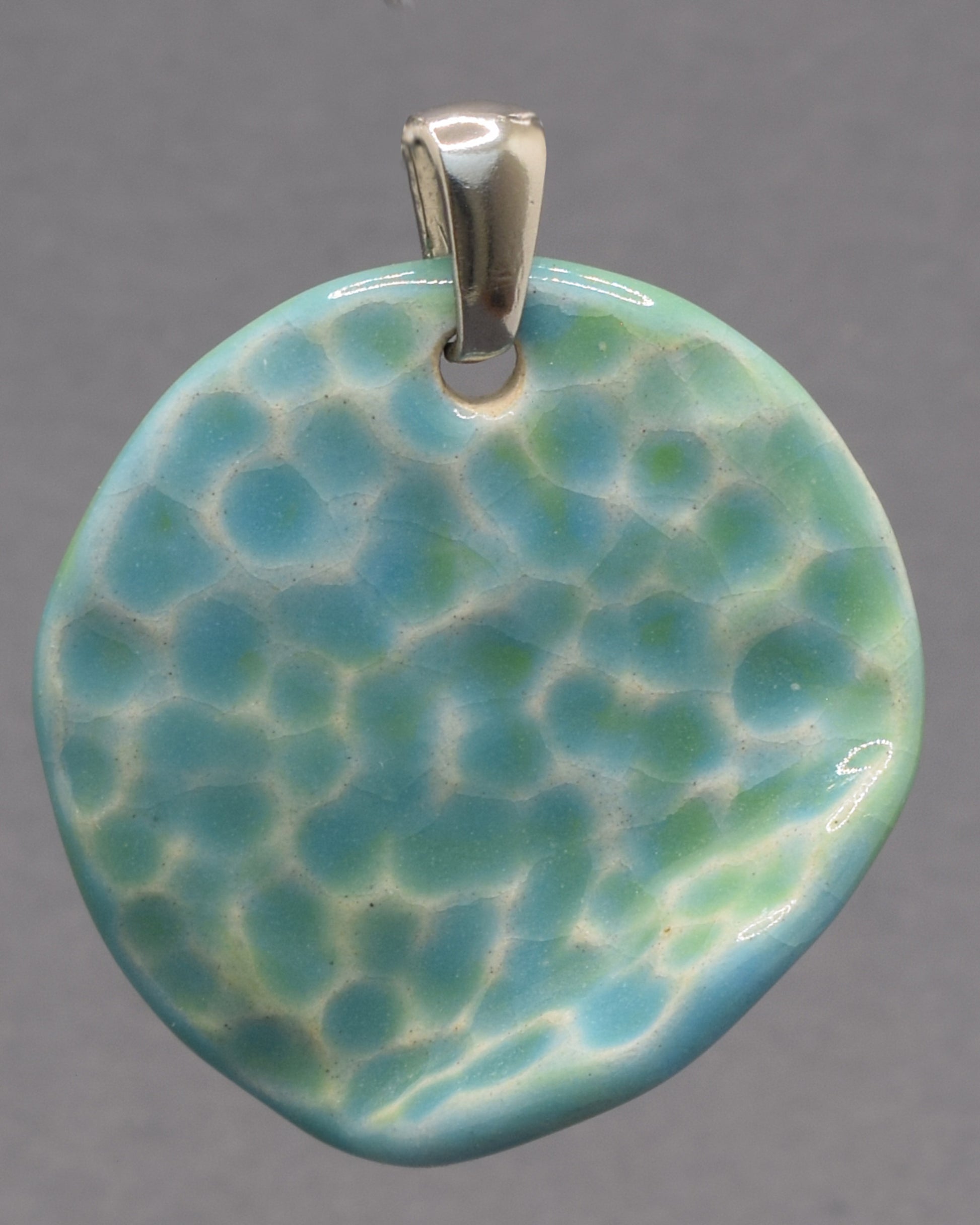 Pendente de cerâmica com textura inspirada nas ondas do mar e acabamento em tons turquesa. Uma peça artesanal única, elegante e cheia de personalidade.